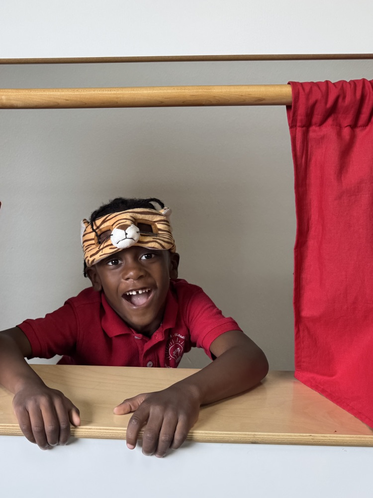 A young boy with a tiger mask resting on his head