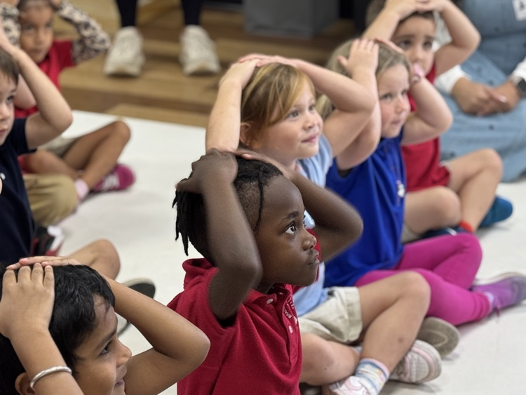 Children with her hands on top of their heads