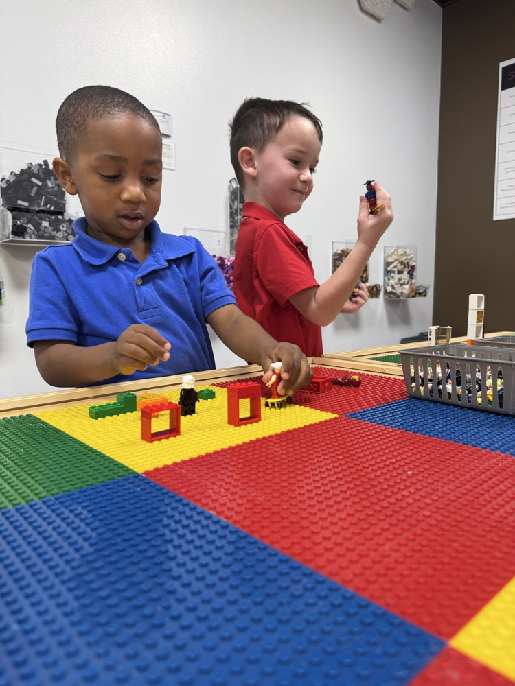 Two children play with Lego bricks