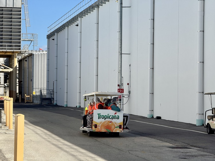 Students ride on a atrium and a manufacturing plant for Tropicana