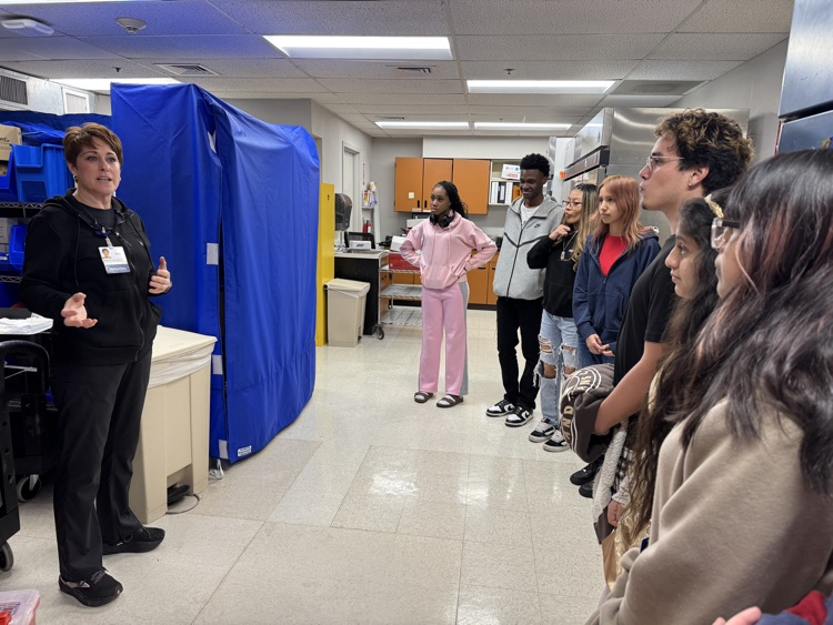 High school students on a field trip in the hospital, listening to a speaker