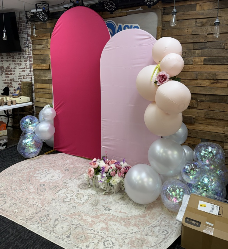 A feather backdrop made of pink and white balloons