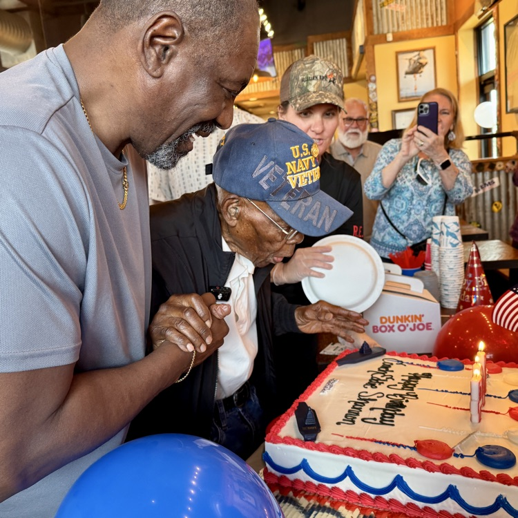 The special birthday guest blows out his candles on a beautiful red white and blue cake