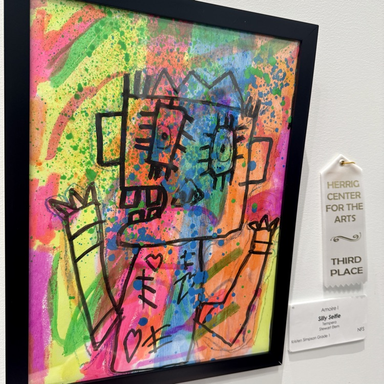 A third place award next to a colorful piece of student art