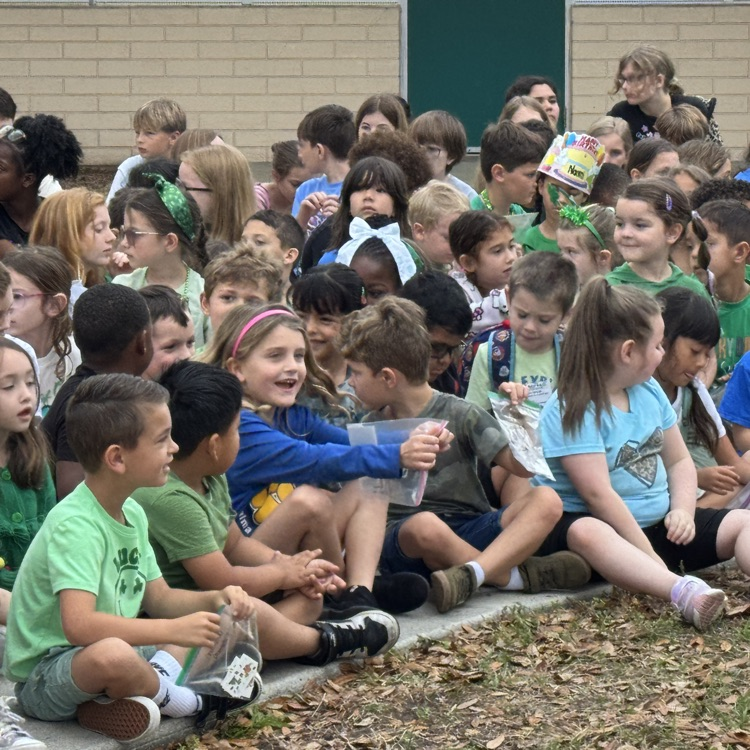 kids sitting in a school courtyard smiling and laughing 