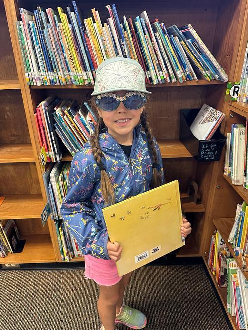 student in the library wearing a hat and sunglasses