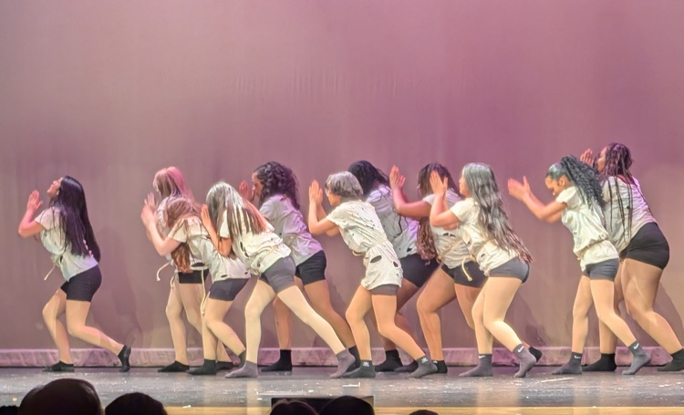 dancers on stage in a high school auditorium 