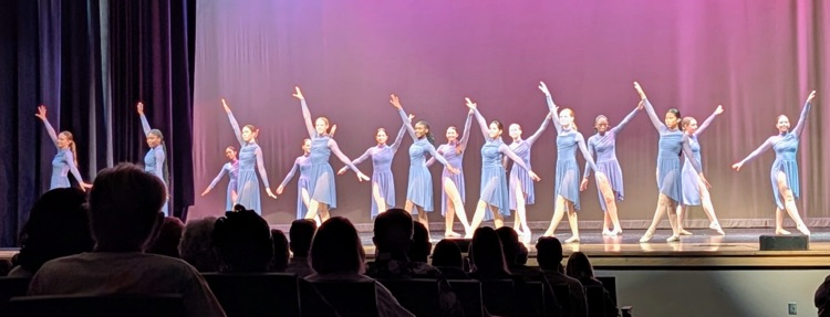 dancers on stage wearing blue dresses