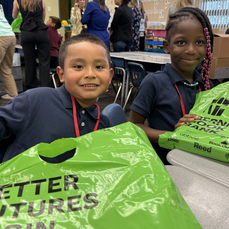 students smiling with green plastic bags 