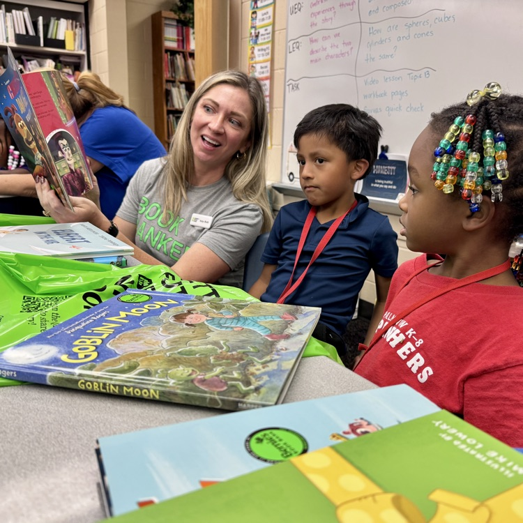 A volunteer reads to two young children 