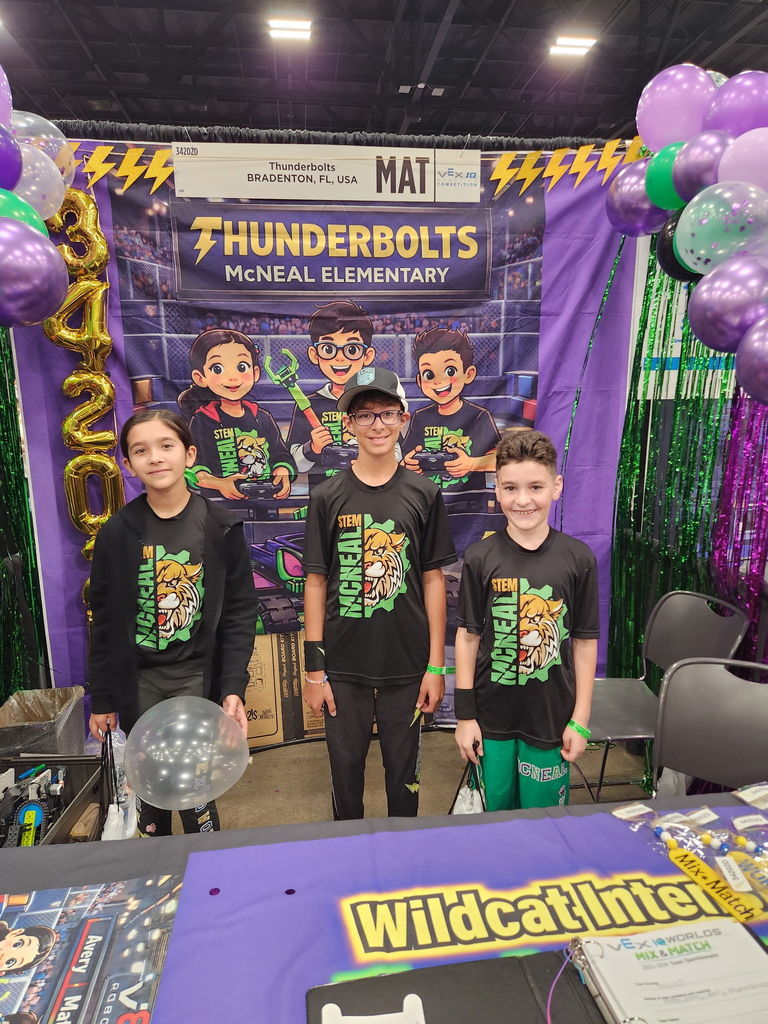 Smiling students standing in front of a display that says "Thunderbolts". 