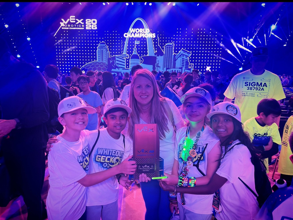 Children holding a trophy in a dark room with a glowing backdrop.