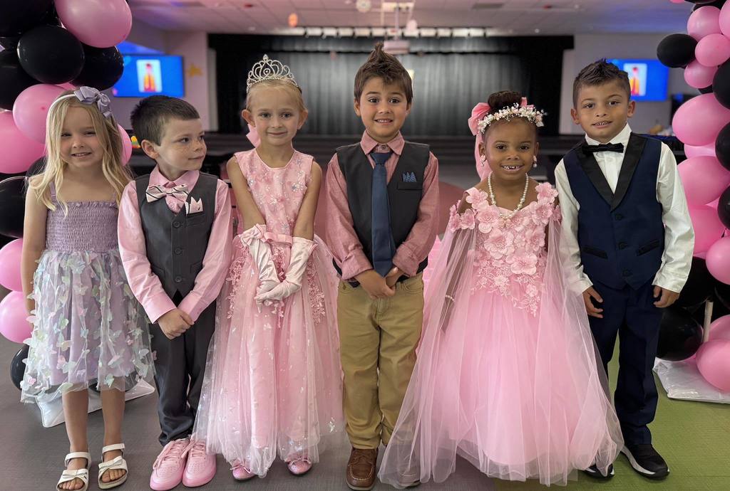 Kids dressed up in fancy dresses and suits for a Pre-K Prom.