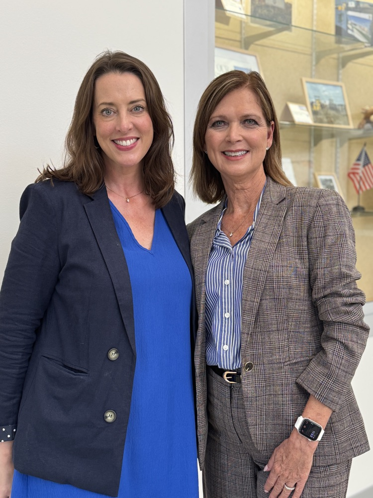 two women in suits smile on the first day of school