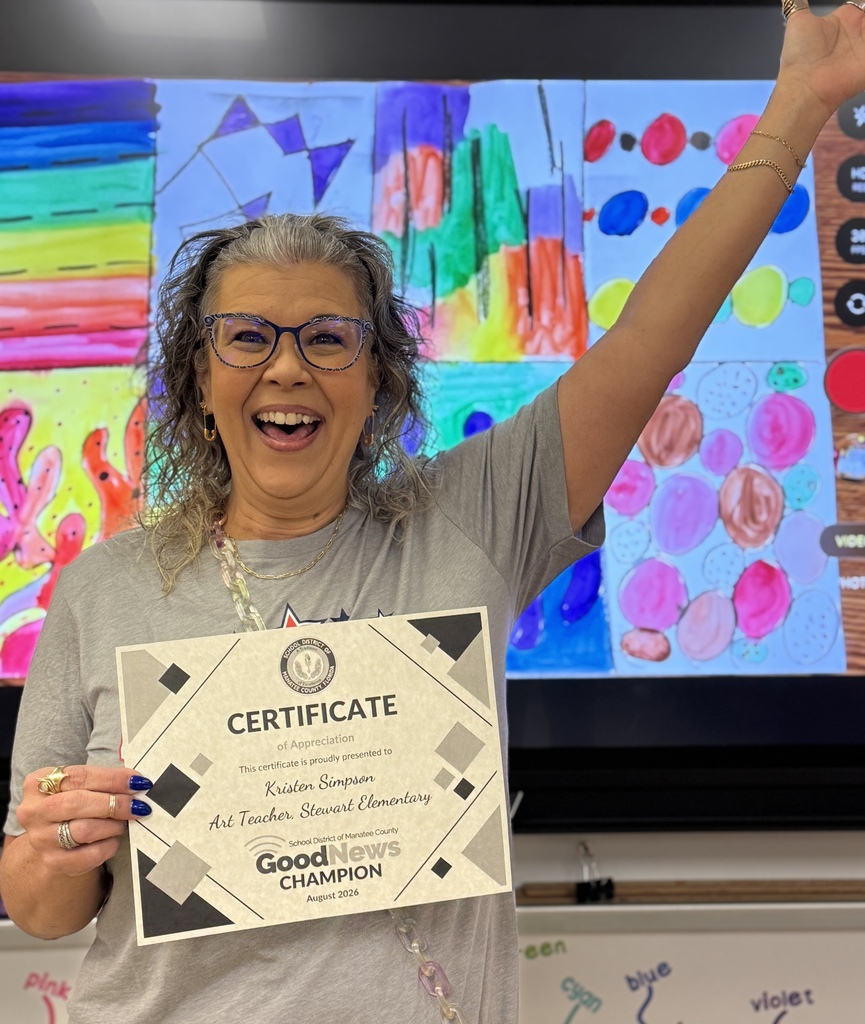A teacher wearing a grey t-shirt and glasses holding a certificate that reads Good News Champion