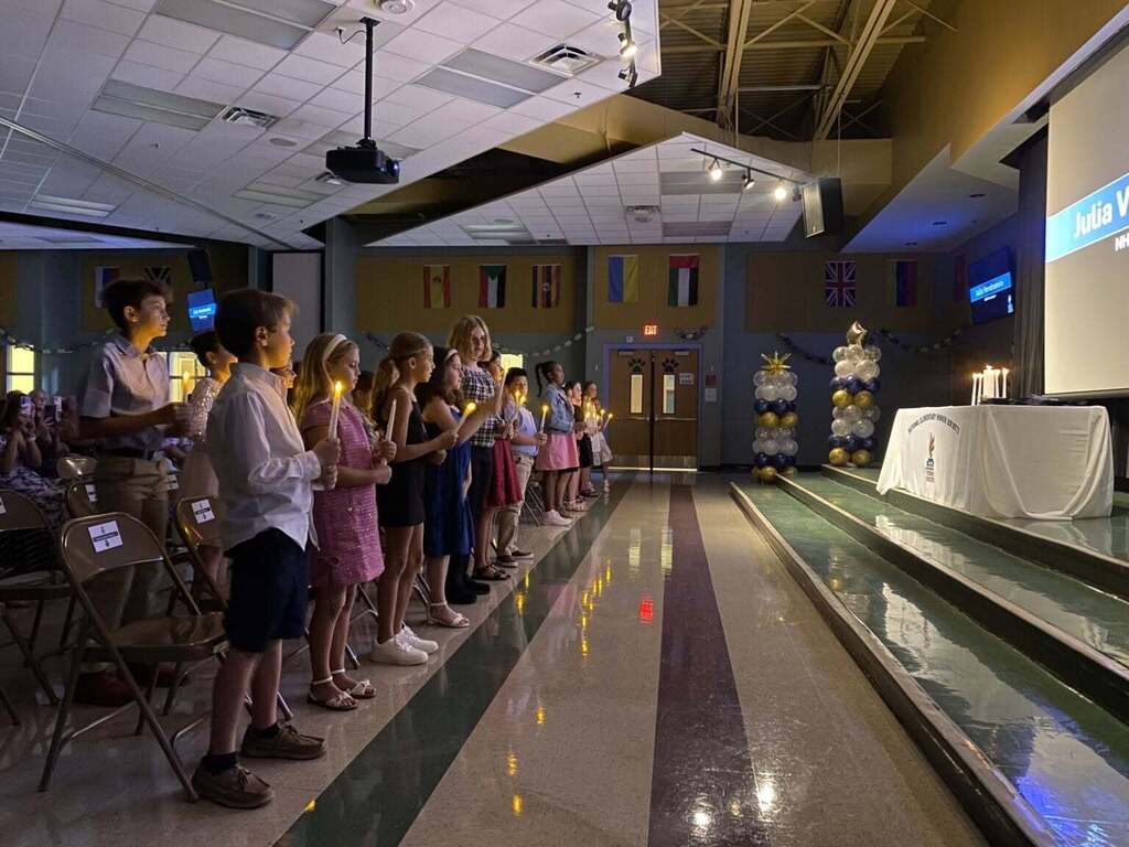 Students holding candles being inducted into the National Elementary Honors Society
