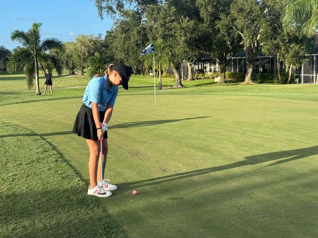Student athlete putts in the ball at Peridia Golf and Country Club.