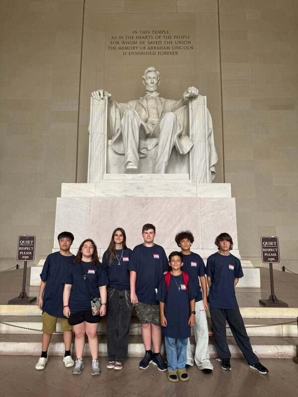 A group of young people standing in front of the Lincoln Memorial in Washington, D.C.