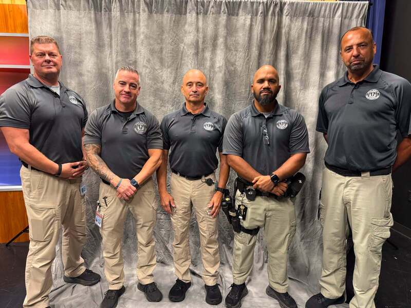 school safety guardians standing in front of a grey curtain