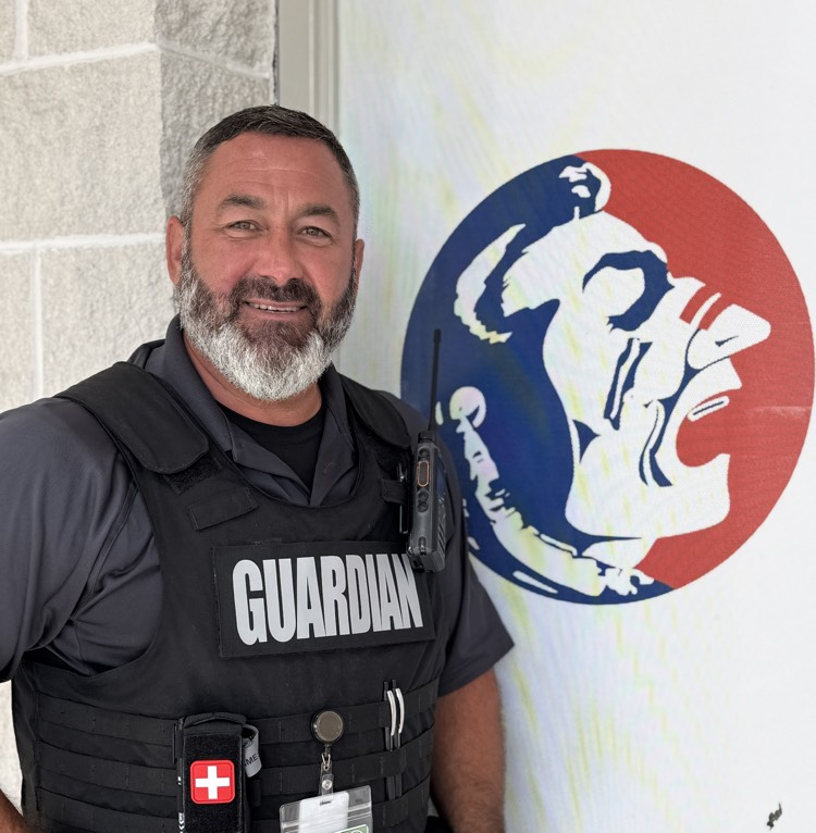 East school safety guardians stands next to a Seminole head Indian logo