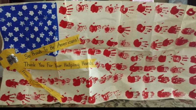An American flag made from children's hand prints and finger paint.