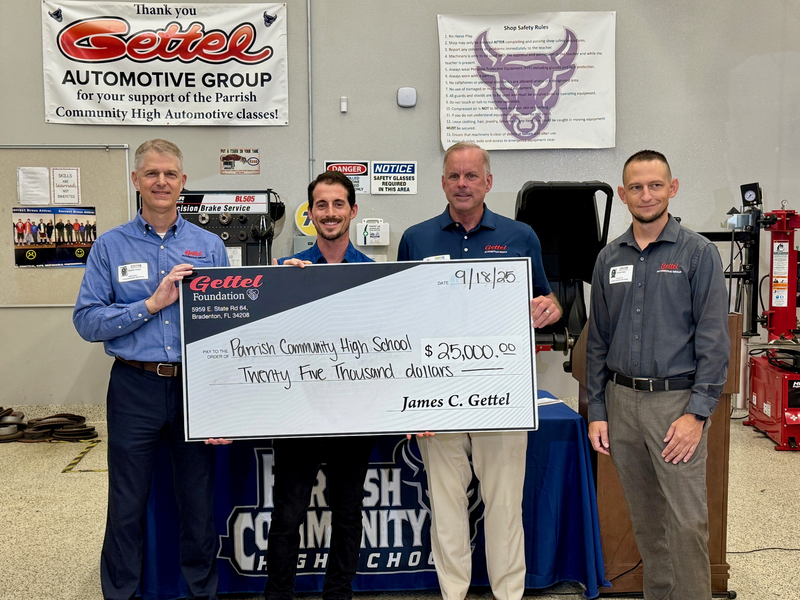 Gettel executives join an automotive instructor of a high school program