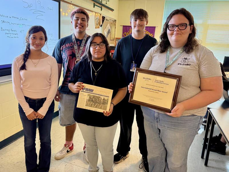 A group of students holding their journalism recognition plaque.
