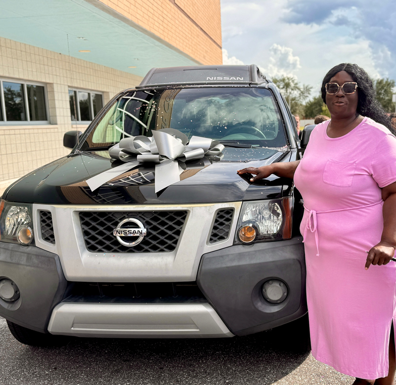 A woman standing next to a pre-owned vehicle which was gifted to her on Tuesday
