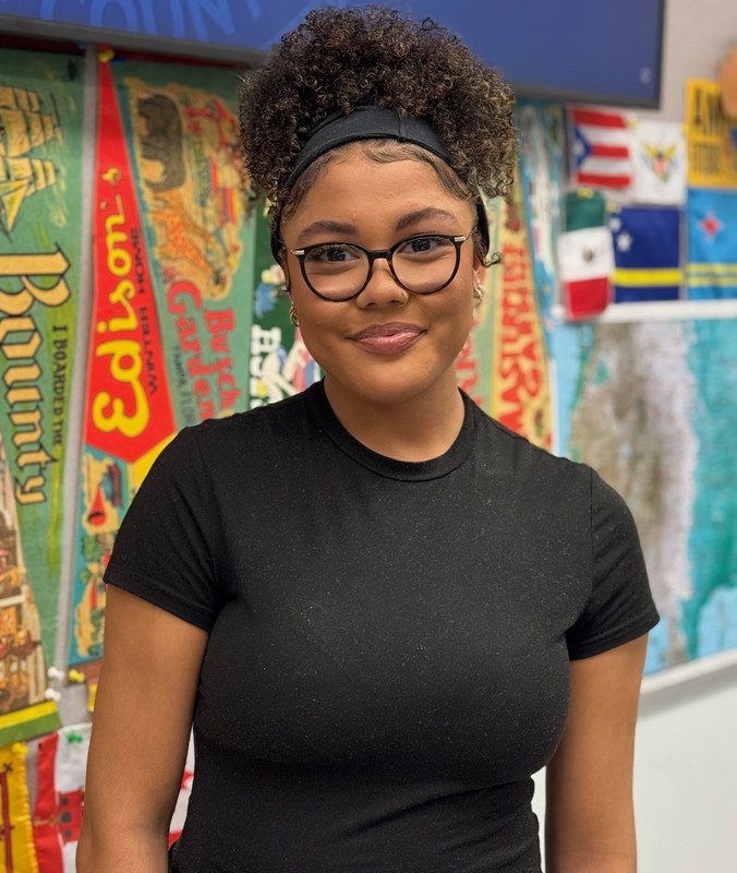 A smiling student wearing a black tshirt and glasses