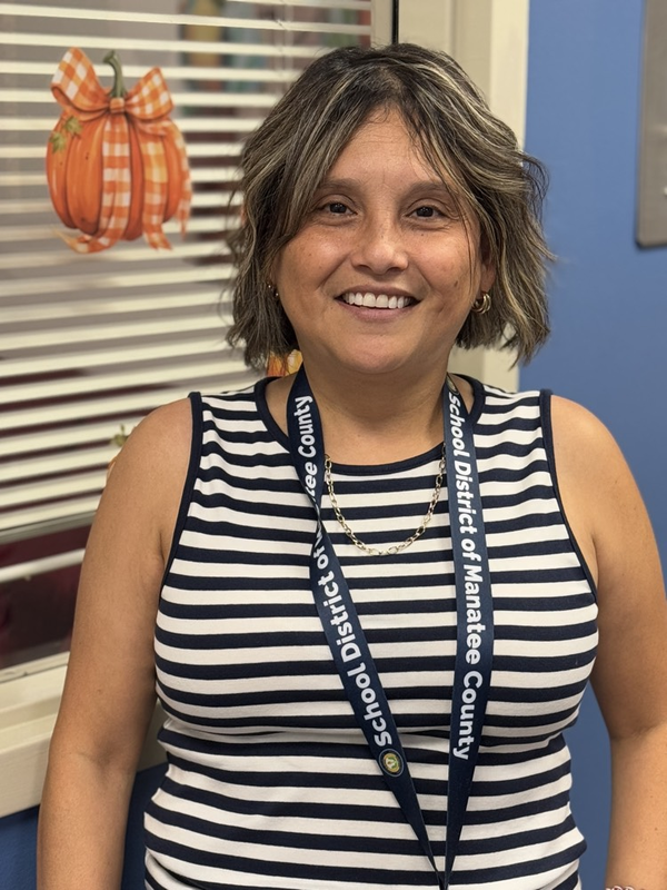 A school employee wearing a striped shirt while smiling
