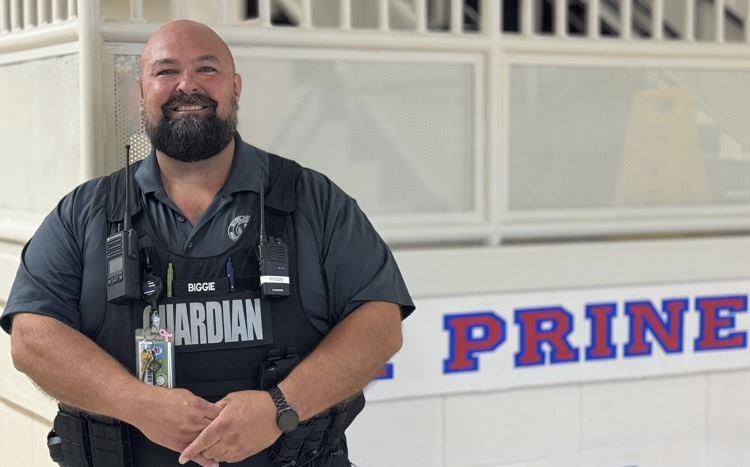 it stands up against the wall with the school name behind him