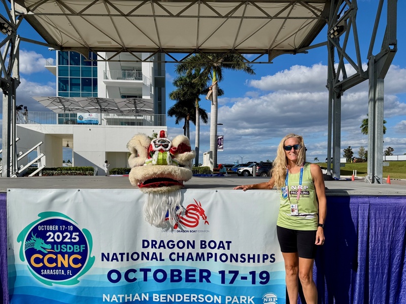 A paddler stands next to a traditional chinese dragon mask at Nathan Benderson Park