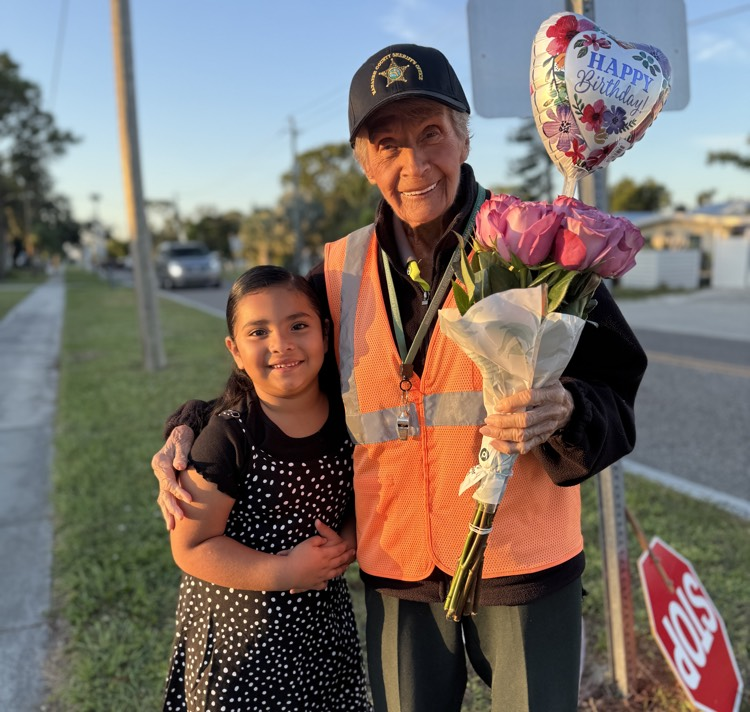 miss Maggie has her arm around a kindergarten student from Palma Sola elementary who delivered a heartfelt birthday gift