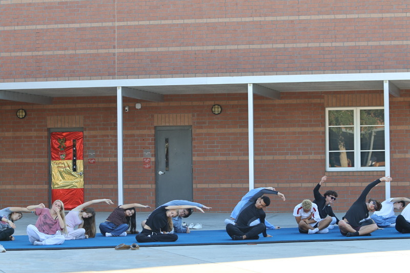 Students doing yoga in a school courtyard.