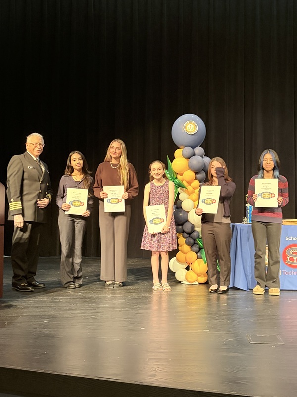 Students holding awards during a STEM ceremony.