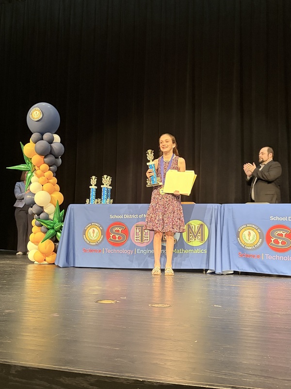 A student holding a trophy.