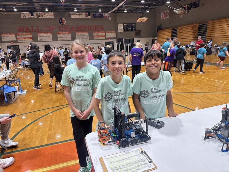 Students smiling with their robot.