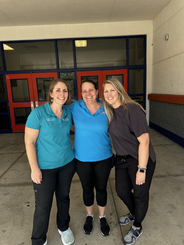 Three school employees smiling.