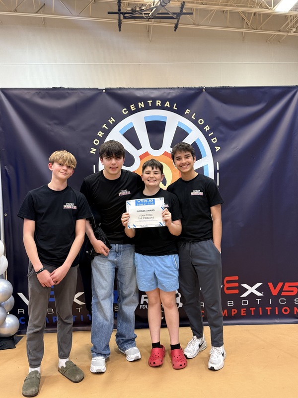 Students holding a certificate at a robotics competition.