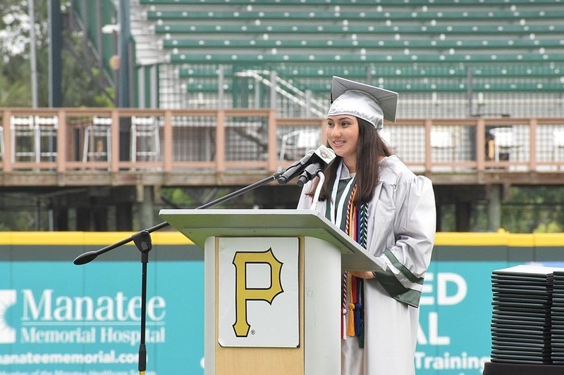 A graduate speaking into a microphone 