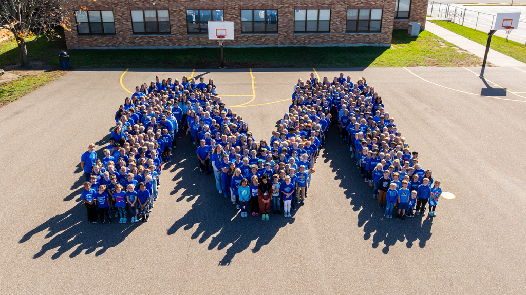 Elementary students standing in the shape of an M.