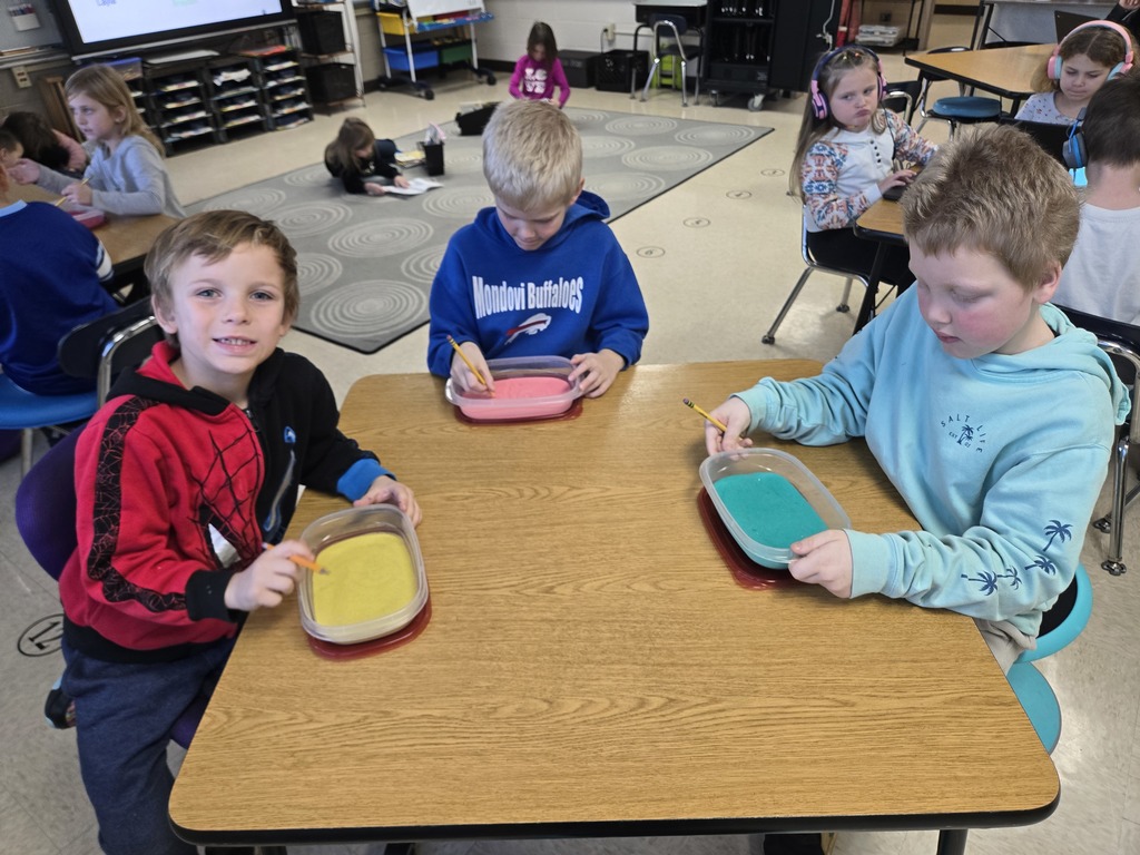 students writing in sand