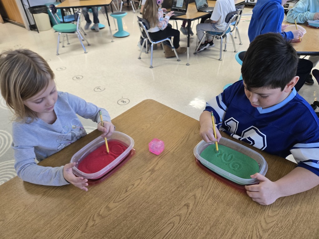 students writing in sand