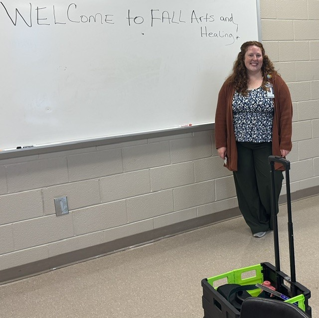 Art Therapist standing in front of a white board.