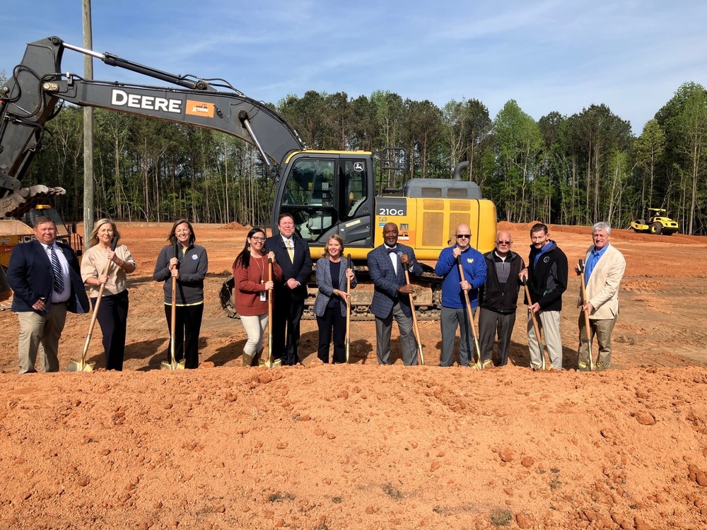 Image of men and women standing with ceremonial shovels. 