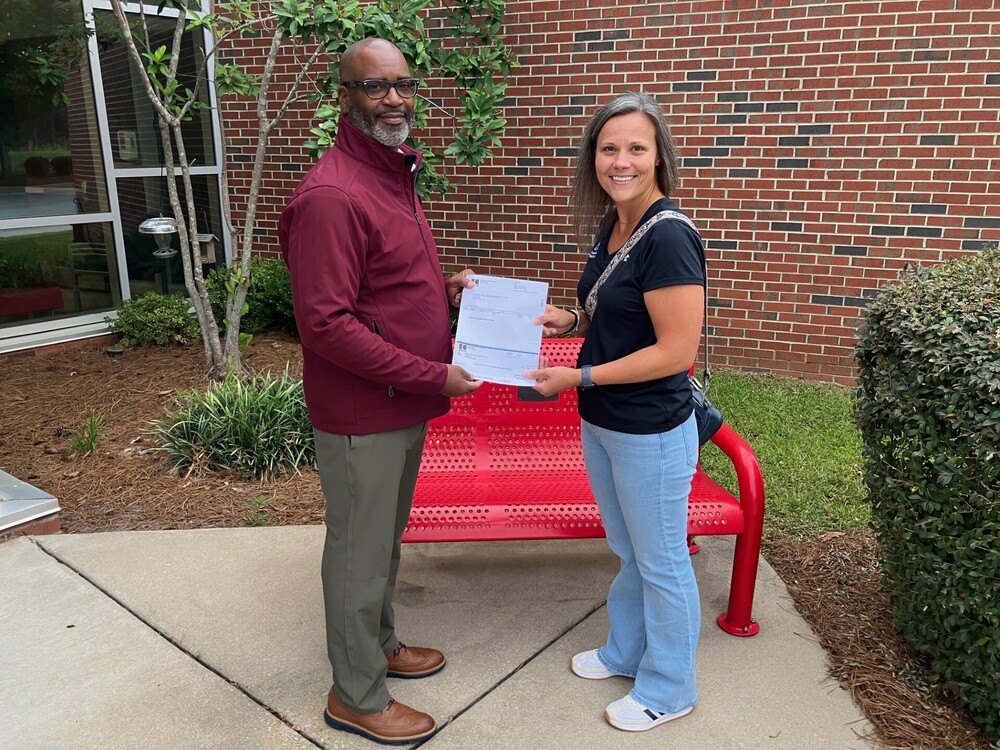 Dr. Anderson and Morgan Bundrick posing with check