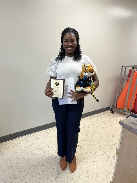 Picture 4: -* Mrs. Geron Wiggins- 7th/8th ELA Teacher- August 2026 Teacher of the Month -pictured with "Teddy the Tiger" & the 27 Point Inspection/Free Oil Change Stokes Trainor Certificate