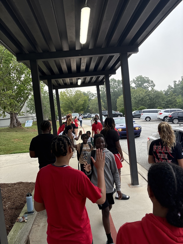 Wide shot of Newberry College basketball women players greeting a student.