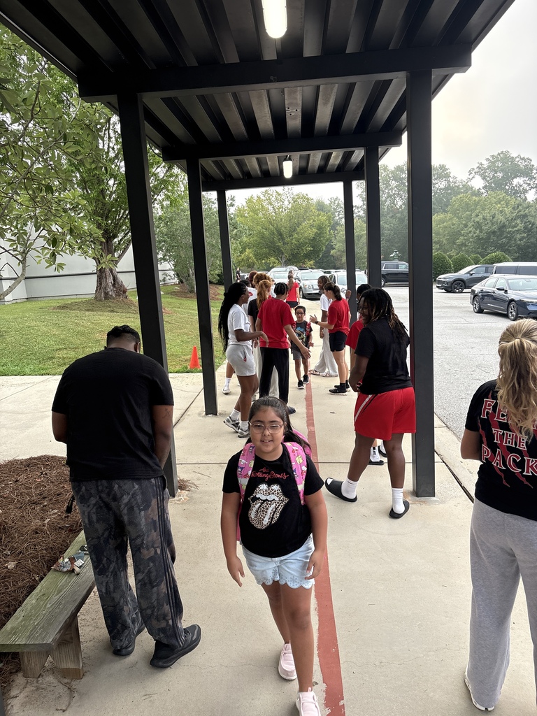 Wide shot of Newberry College basketball women players greeting a student.