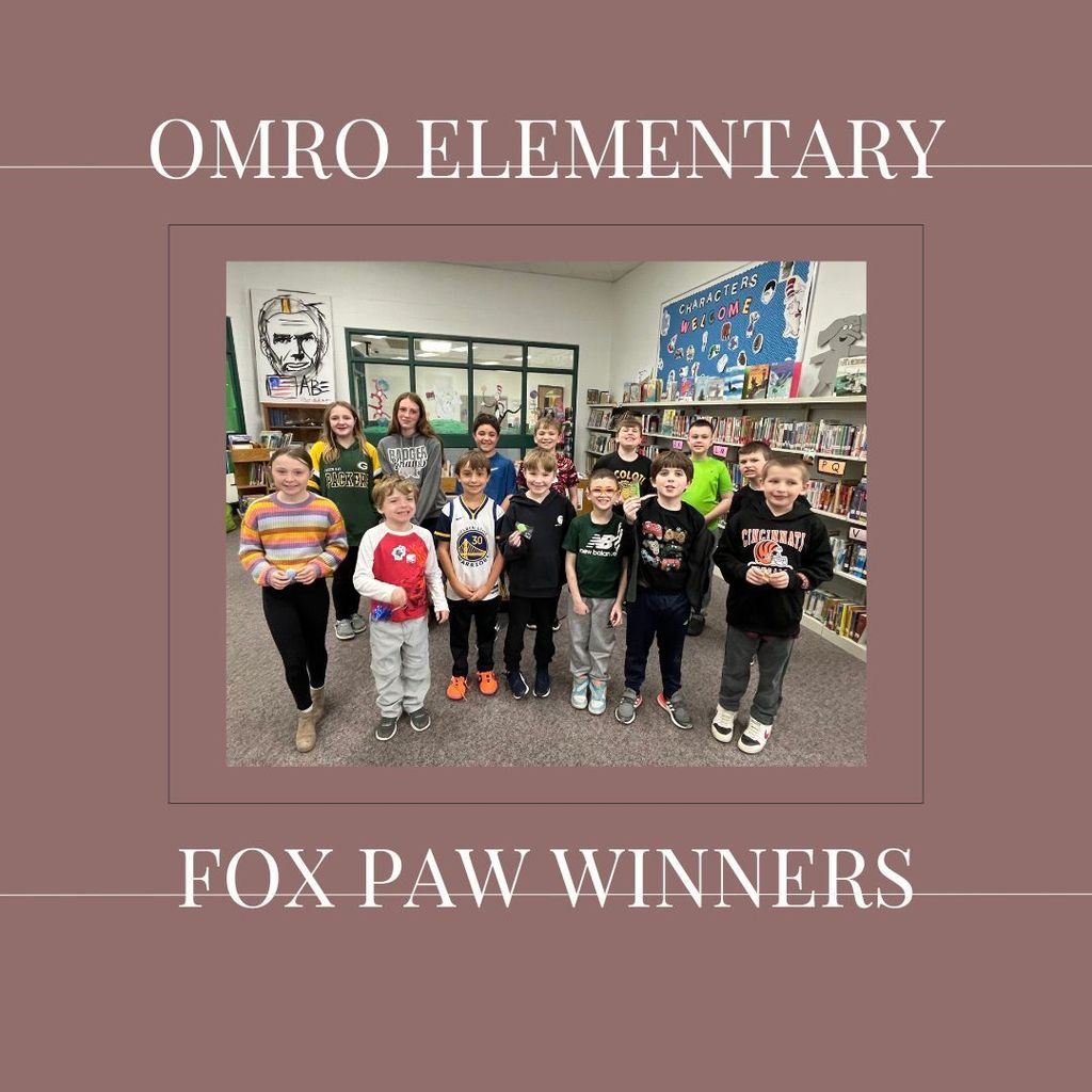 A group of elementary students standing in a media center.